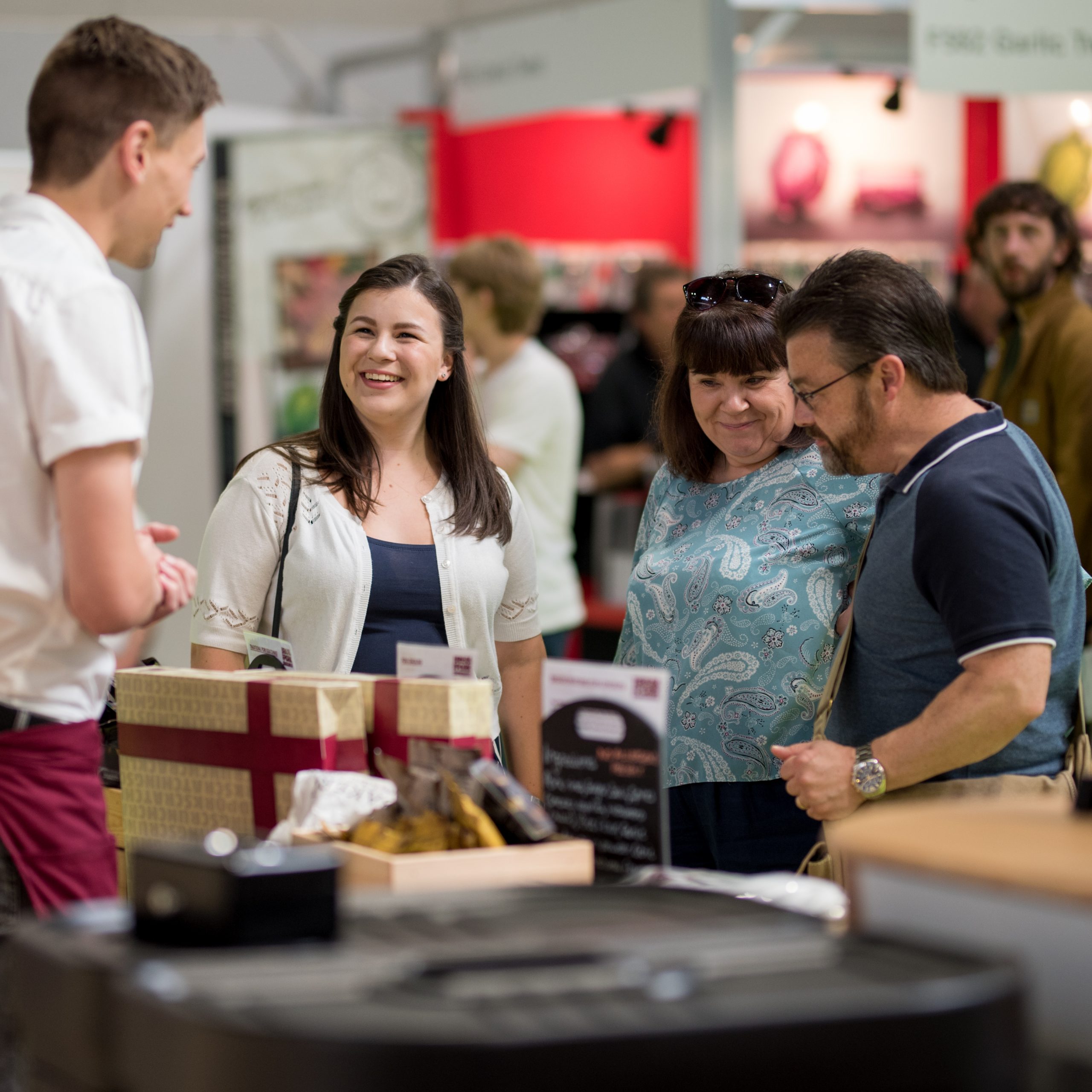 Festivalgoers speaking with an exhibitor at the BBC Good Food Show Summer