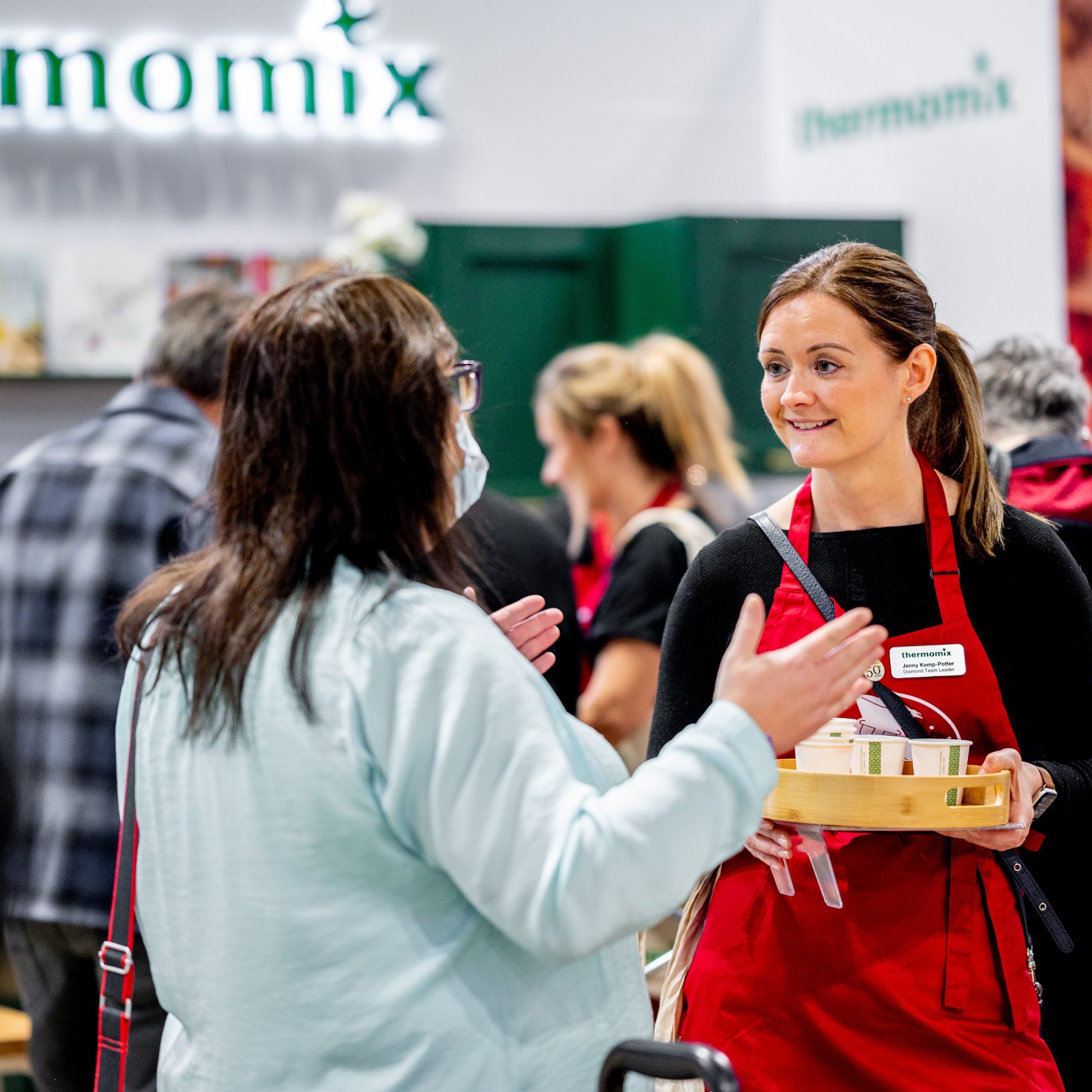 Thermomix representative with a tray of samples, talking to a customer